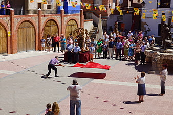 Spanish religious procession in a town square with crowd