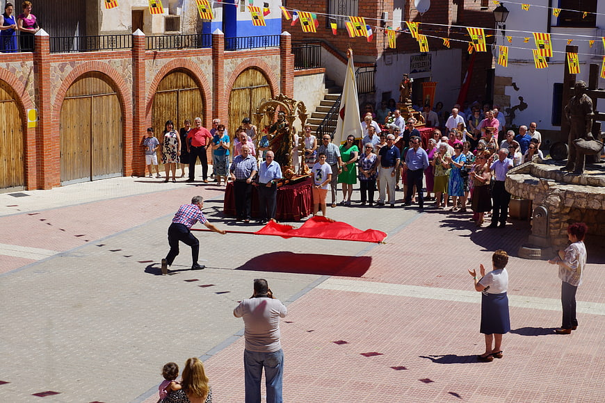 Spanish religious procession in a town square with crowd