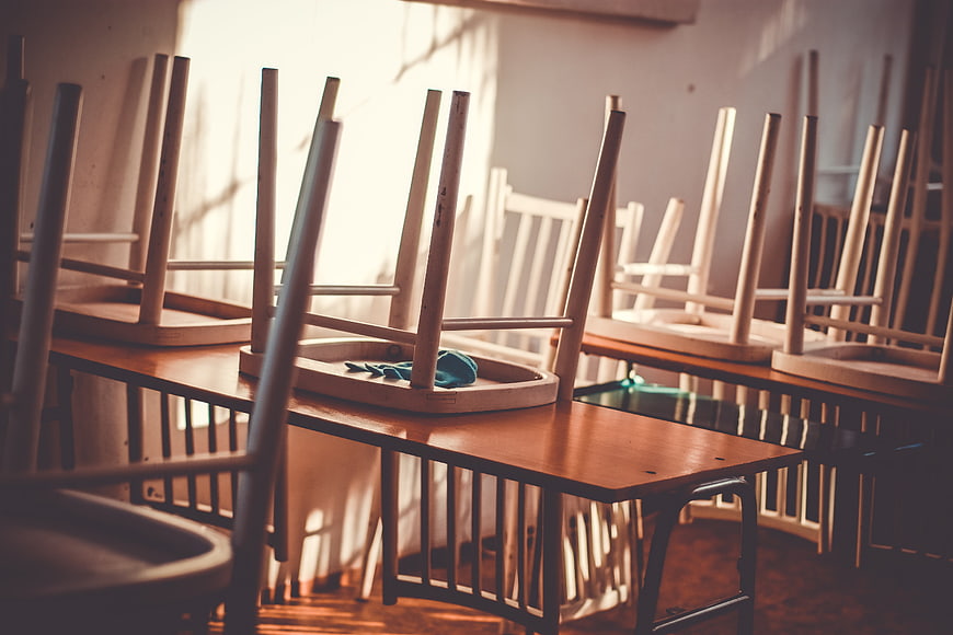 Empty Classroom with Chairs on Desks in Sunlight