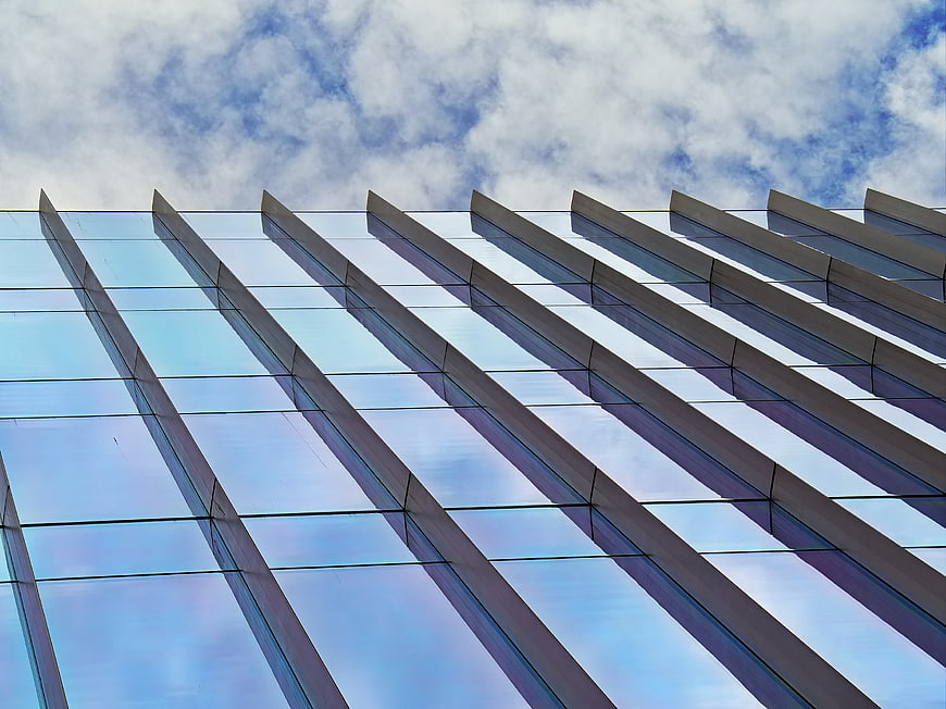 Modern Glass Building Facade with Blue Sky Reflection