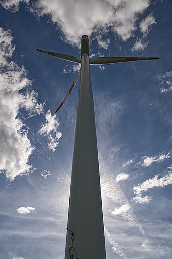 Low angle view of wind turbine against blue sky