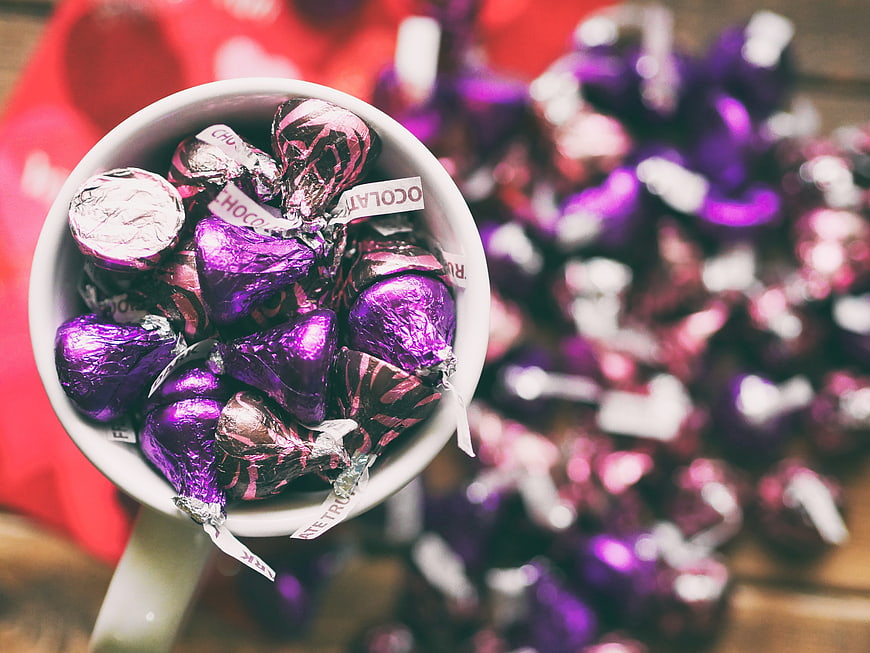 White Mug Filled with Purple Foil Chocolate Kisses