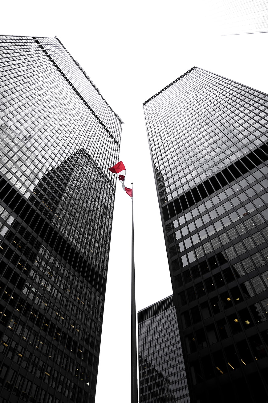 Low angle view of skyscrapers with red flag