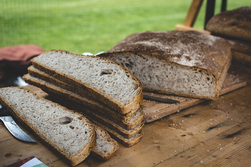 Sliced rustic sourdough bread on wooden table