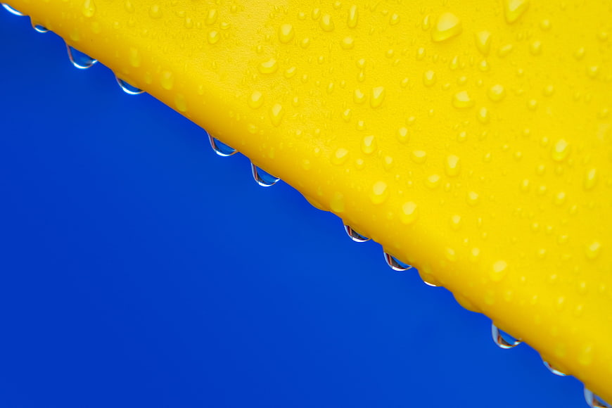 Yellow Surface with Water Droplets on Blue Background