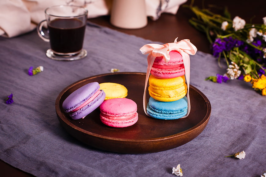 Colorful Macarons Gift Box With Coffee And Flowers On Table