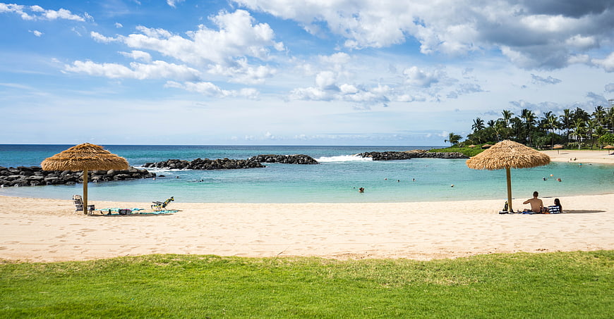 Tropical Beach Landscape With Thatched Umbrellas And Turquoise Ocean Water