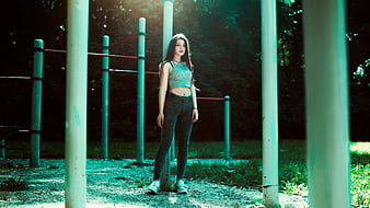 Young Woman Standing in Outdoor Gym with Teal Filter