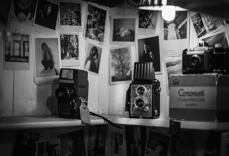 Vintage Cameras and Polaroid Photos on Wooden Shelf