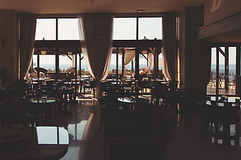 Sunlit restaurant interior with ocean view through large windows