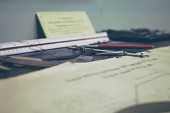 Vintage drafting tools on wooden desk with blueprint