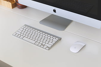 Minimalist white desk with Apple iMac, keyboard, and mouse