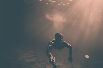 Underwater Diver Selfie With Dramatic Sunbeams And Muted Ocean Tones