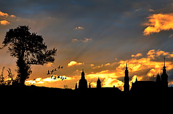 Silhouette of European city skyline with church spires at sunset