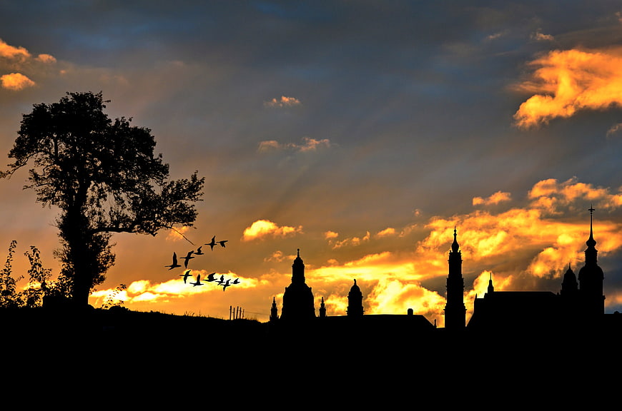 Silhouette of European city skyline with church spires at sunset