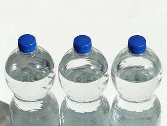 Three Clear Plastic Water Bottles with Blue Caps on White Background