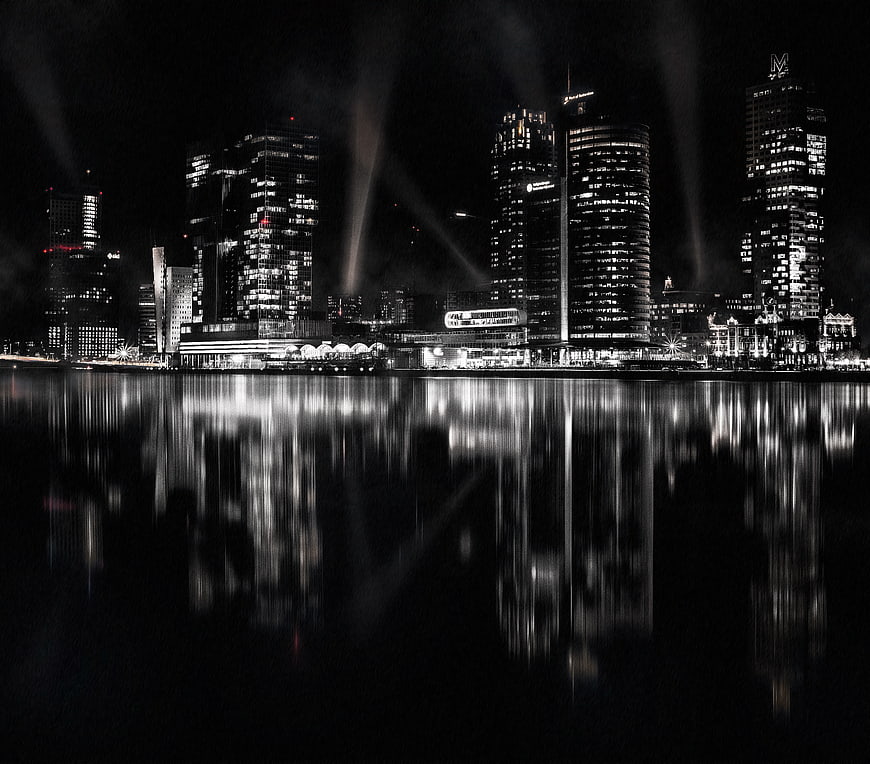 Black and white night cityscape with water reflections