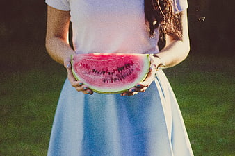 Woman holding fresh watermelon slice in summer