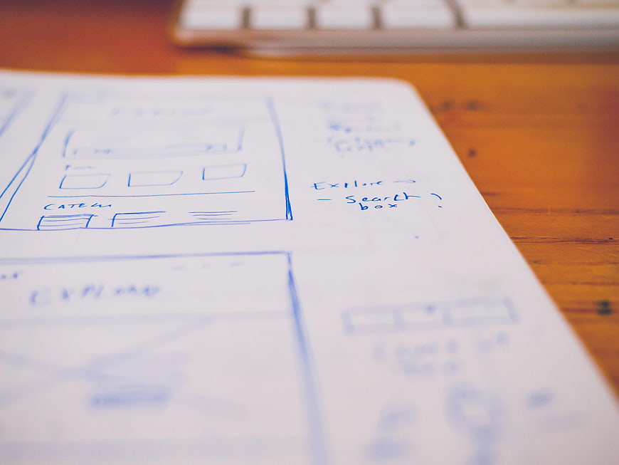 Hand-drawn wireframe sketches on paper for web design