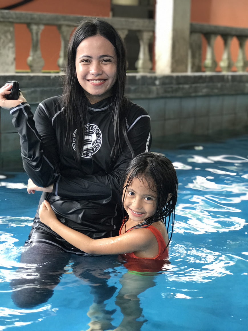 Smiling woman and child in swimming pool