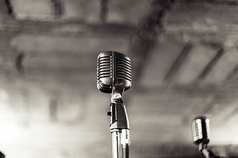 Vintage Microphone on Stand Against Blurred Brick Wall