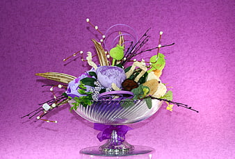 Purple floral arrangement in glass bowl on pink background