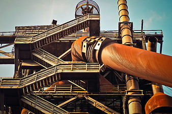 Low angle view of rusty industrial pipes and metal structures