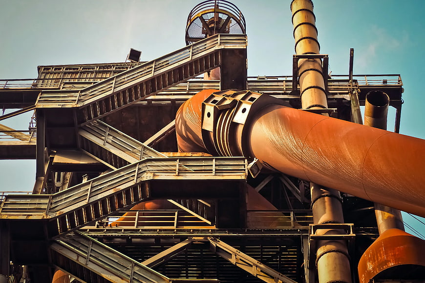 Low angle view of rusty industrial pipes and metal structures