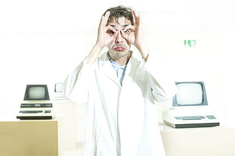 Man in lab coat making funny face with hands