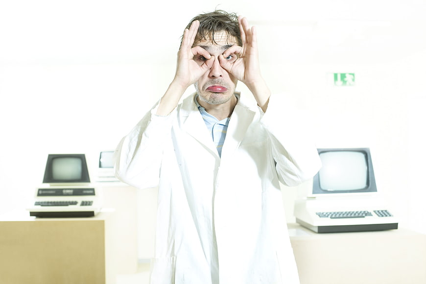 Man in lab coat making funny face with hands
