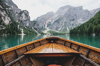 Wooden boat on turquoise alpine lake with mountains