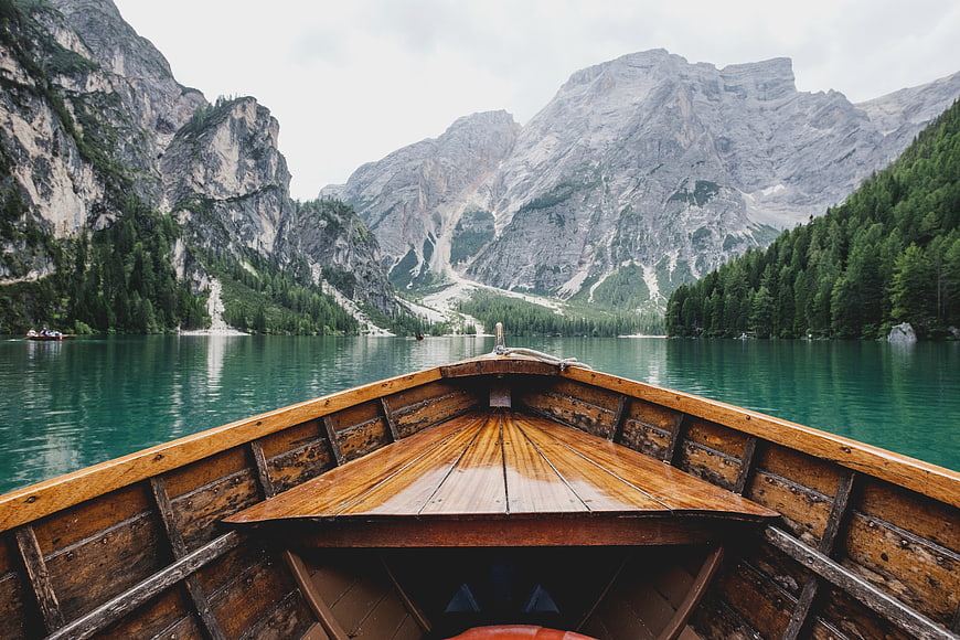 Wooden boat on turquoise alpine lake with mountains
