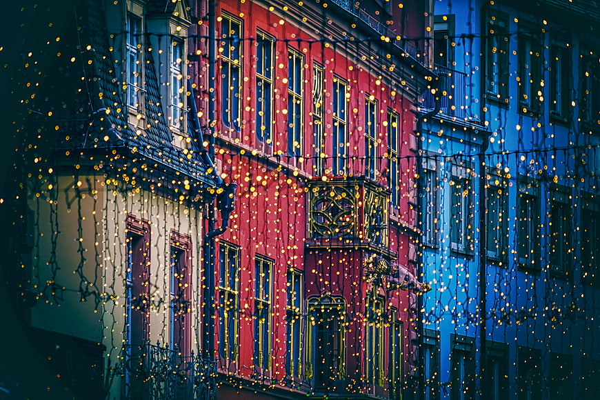 Colorful European Townhouses With Christmas Fairy Lights At Night