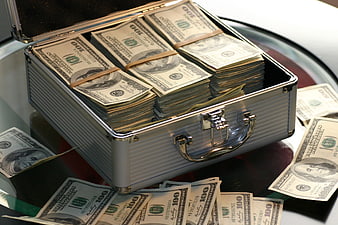 Silver briefcase filled with stacks of hundred dollar bills
