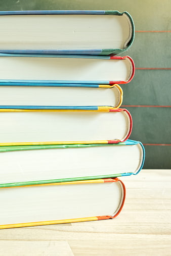 Stack of colorful books on wooden table