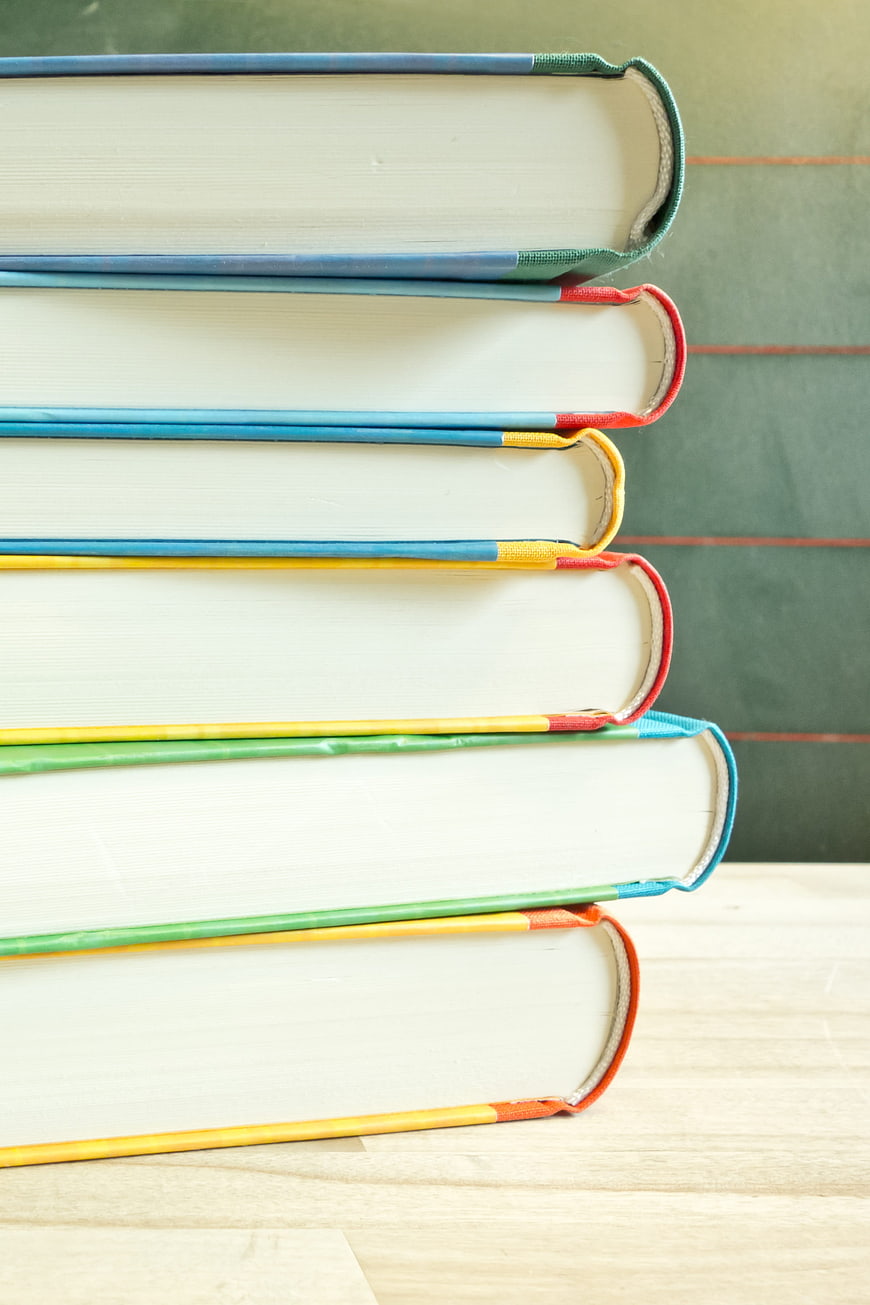 Stack of colorful books on wooden table