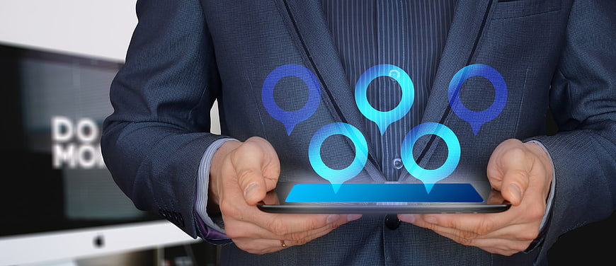 Businessman holding tablet with holographic IoT network map icons