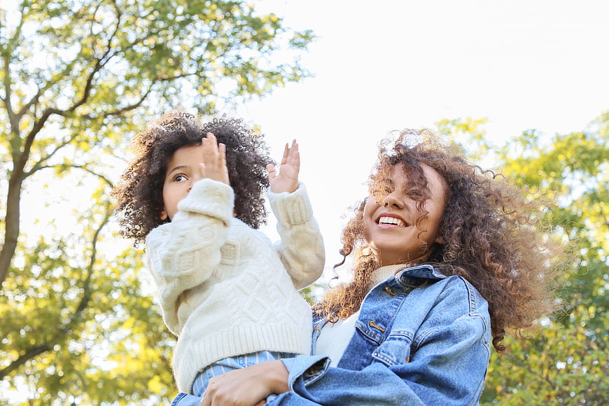 Happy Mother and Daughter Playing Outside in Park
