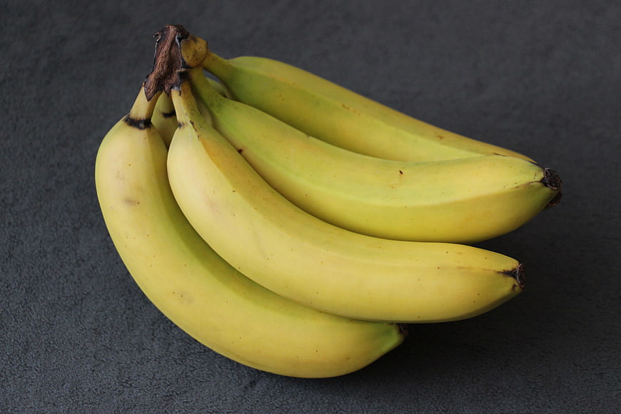 Bunch of Ripe Yellow Bananas on Dark Gray Textured Surface