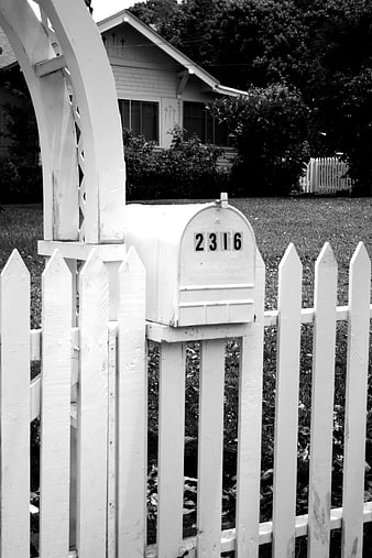 White Mailbox on Picket Fence in Black and White