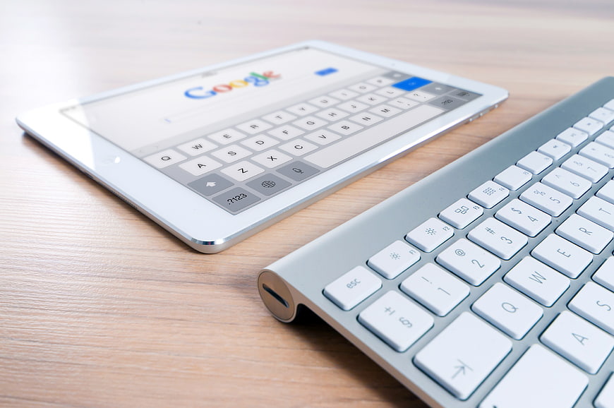 White tablet and keyboard on wooden desk