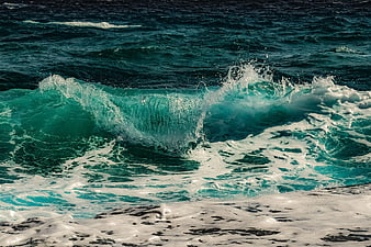 Powerful turquoise ocean wave crashing with white sea foam
