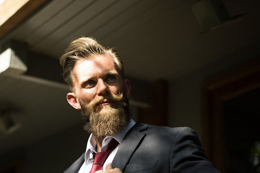 Handsome Bearded Man in Suit Adjusting Tie