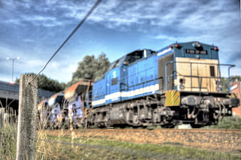 Blue Freight Train on Tracks with Wooden Fence Post
