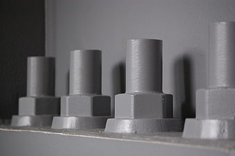 Close-up of gray industrial bolts on metal surface