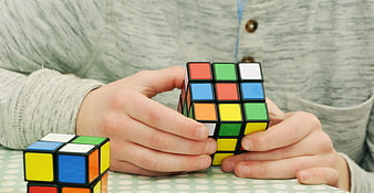 Child hands solving colorful Rubik's cube puzzle