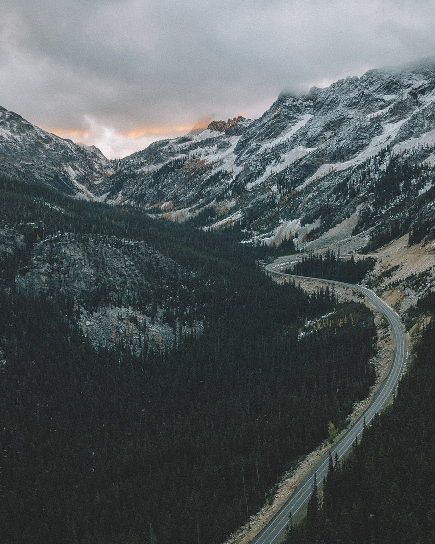 Winding Mountain Road Through Snowy Forest Valley