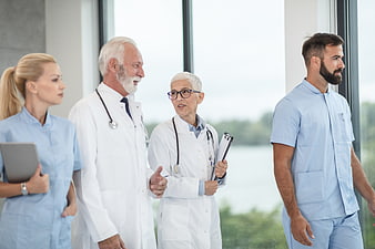 Diverse medical team walking and discussing in hospital corridor