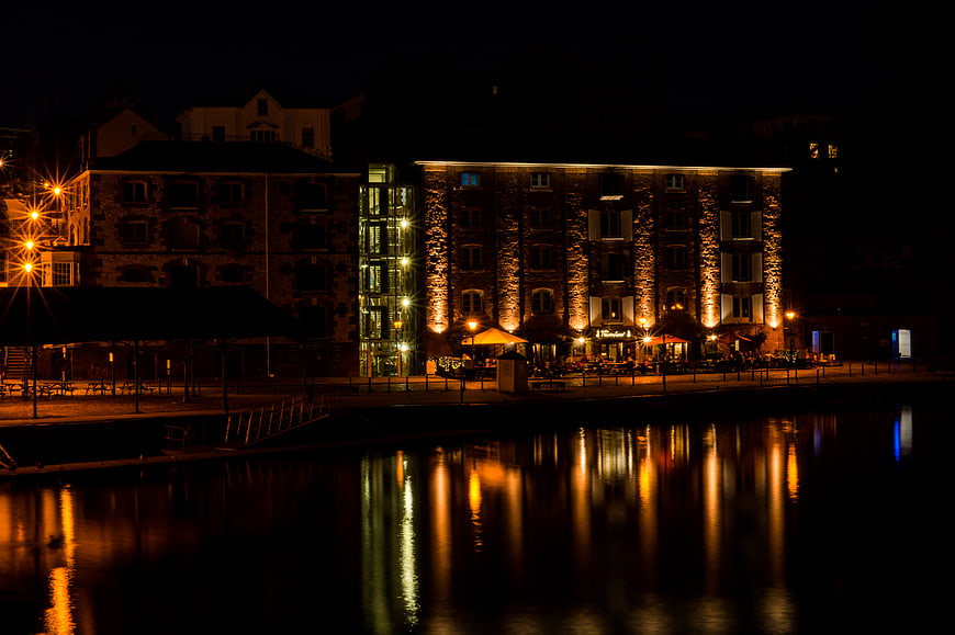 Night View of Illuminated Riverside Restaurant with Water Reflections