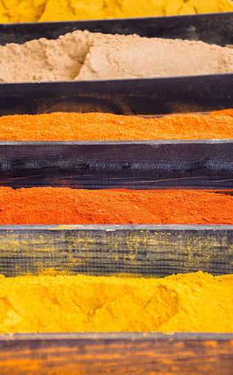 Colorful spice powders in wooden market bins